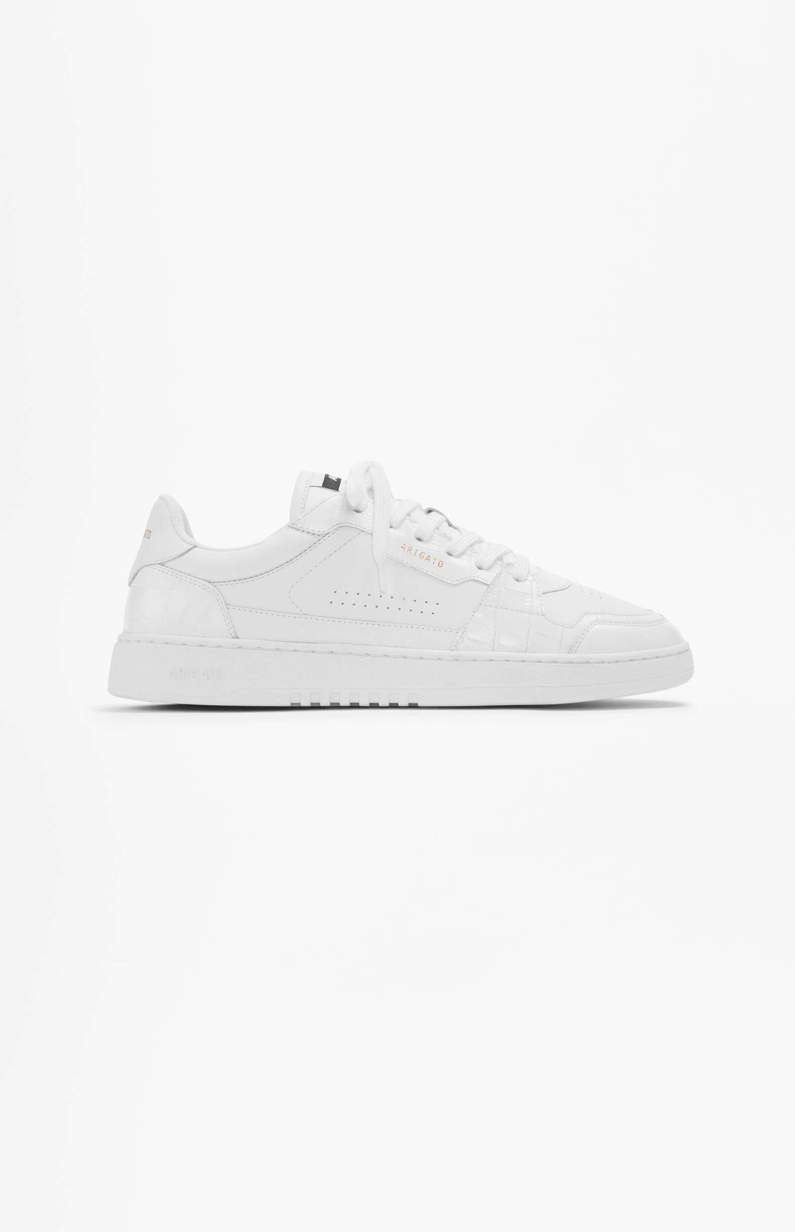A single white Axel Arigato low-top sneaker with white laces, subtle textured details, and gold 'ARIGATO' branding on the side, presented against a plain white background.