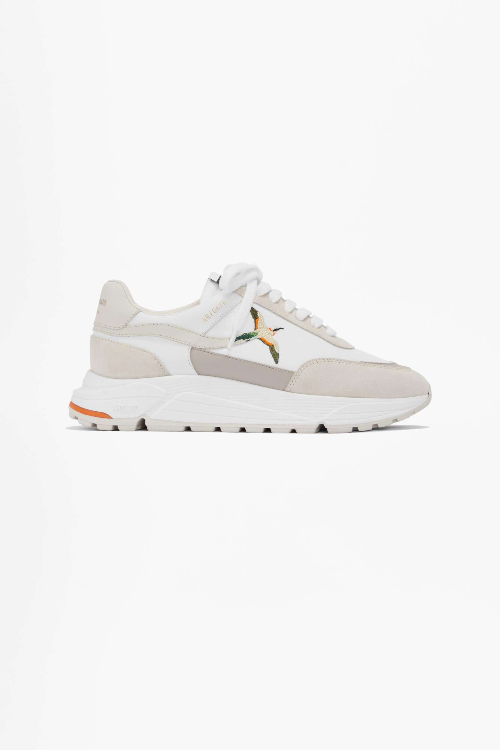 A white and beige Axel Arigato sneaker featuring an embroidered flying duck motif on the side, displayed on a plain white background.