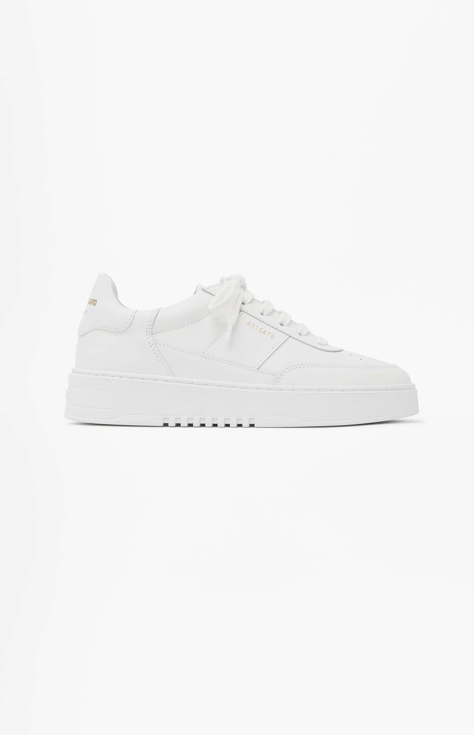 A single white leather sneaker with 'ARIGATO' embossed in gold on the side, displayed from a slightly angled profile on a minimalist white background.