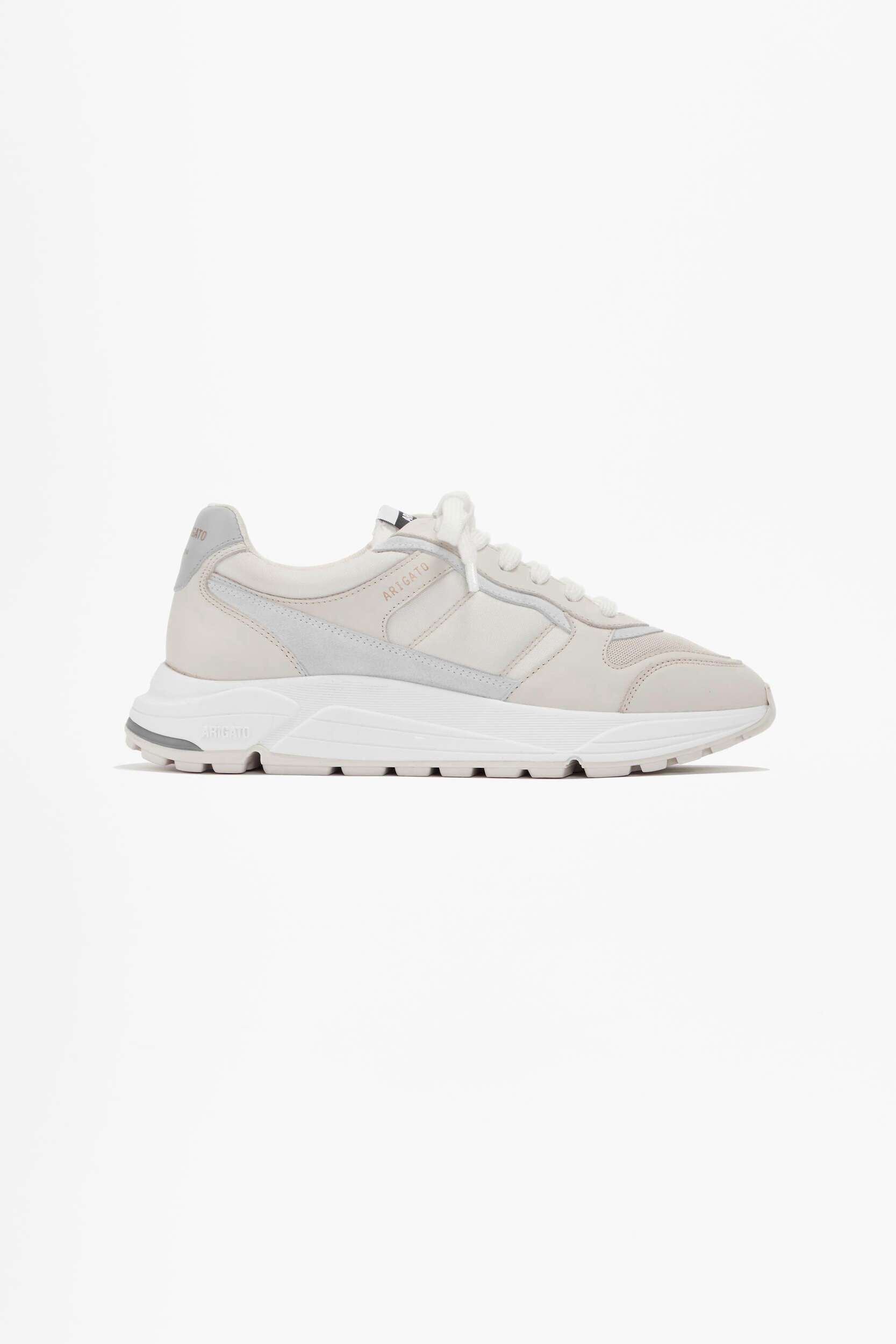 A light beige and light grey athletic sneaker with a thick white sole and 'ARIGATO' branding on the side, viewed from a side angle on a white background.