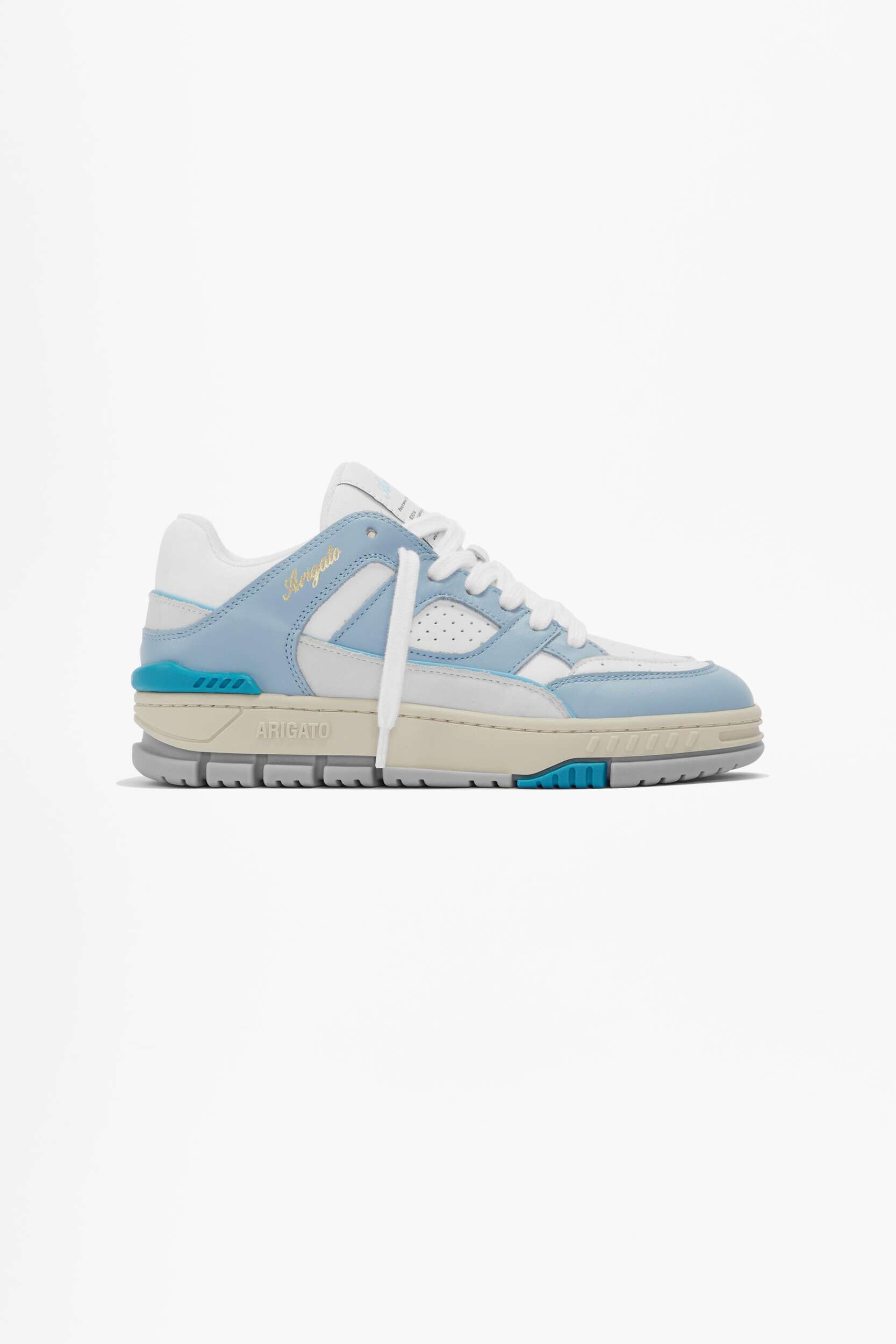 A white and light blue Axel Arigato Delta sneaker with a chunky beige, grey, and turquoise sole, featuring the 'Arigato' logo in gold script on the side, presented against a plain white background.