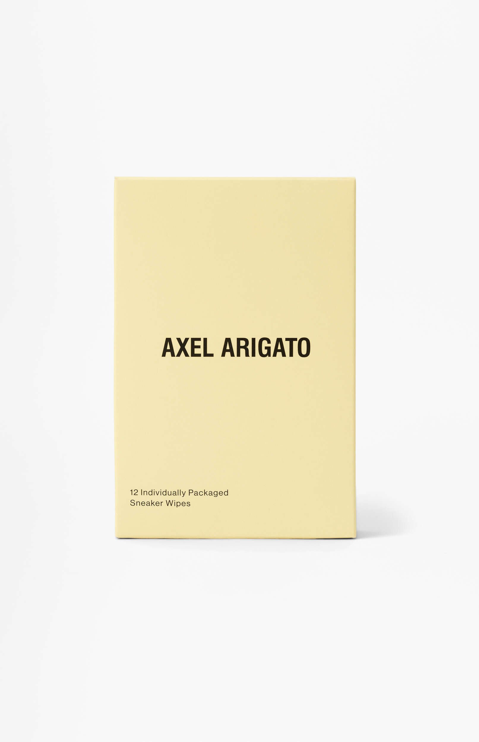 A light yellow box of Axel Arigato 12 individually packaged sneaker wipes stands upright on a white background.