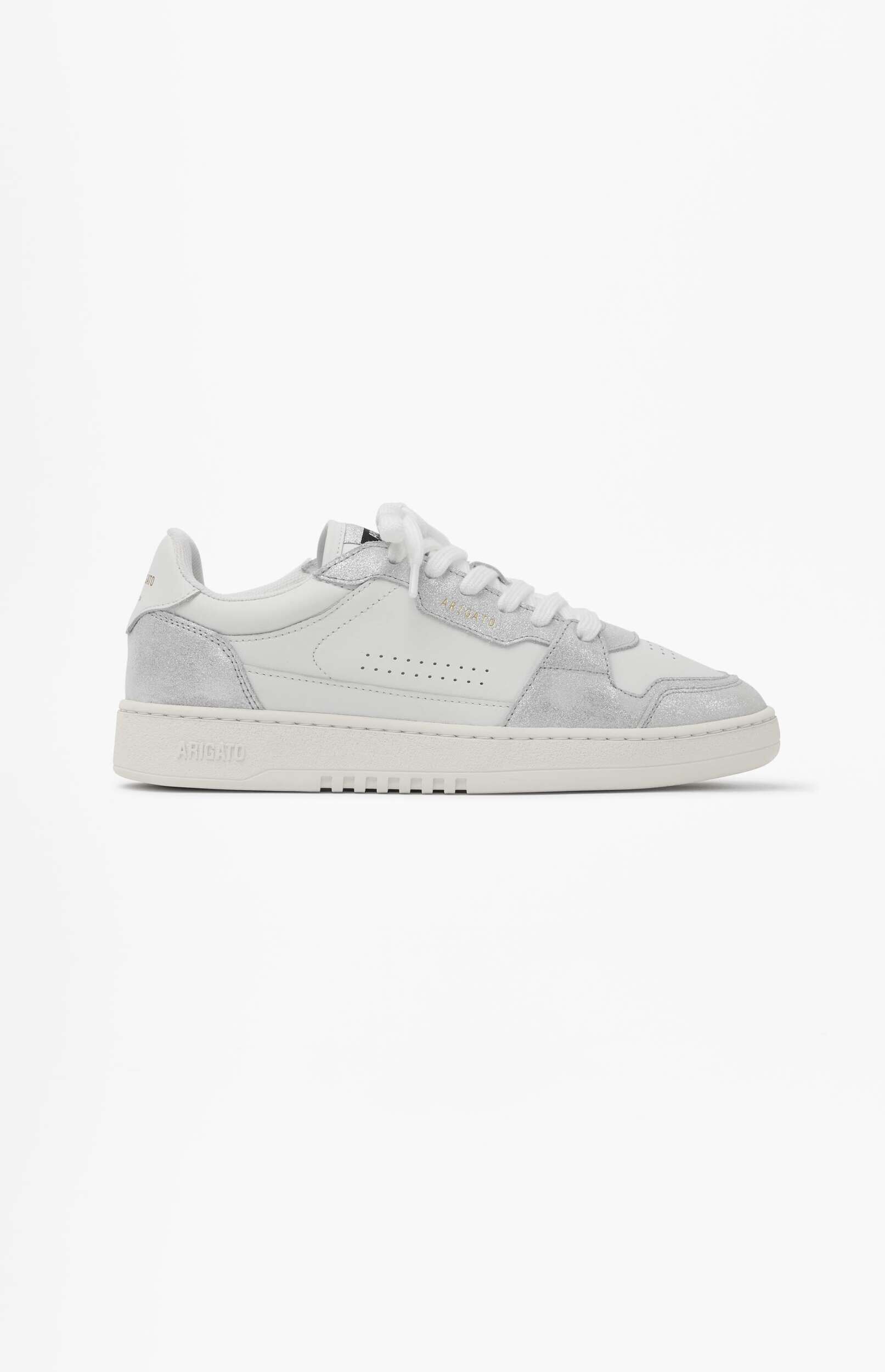 A white Axel Arigato low-top sneaker with silver metallic details and white laces, positioned at an angle on a white background.