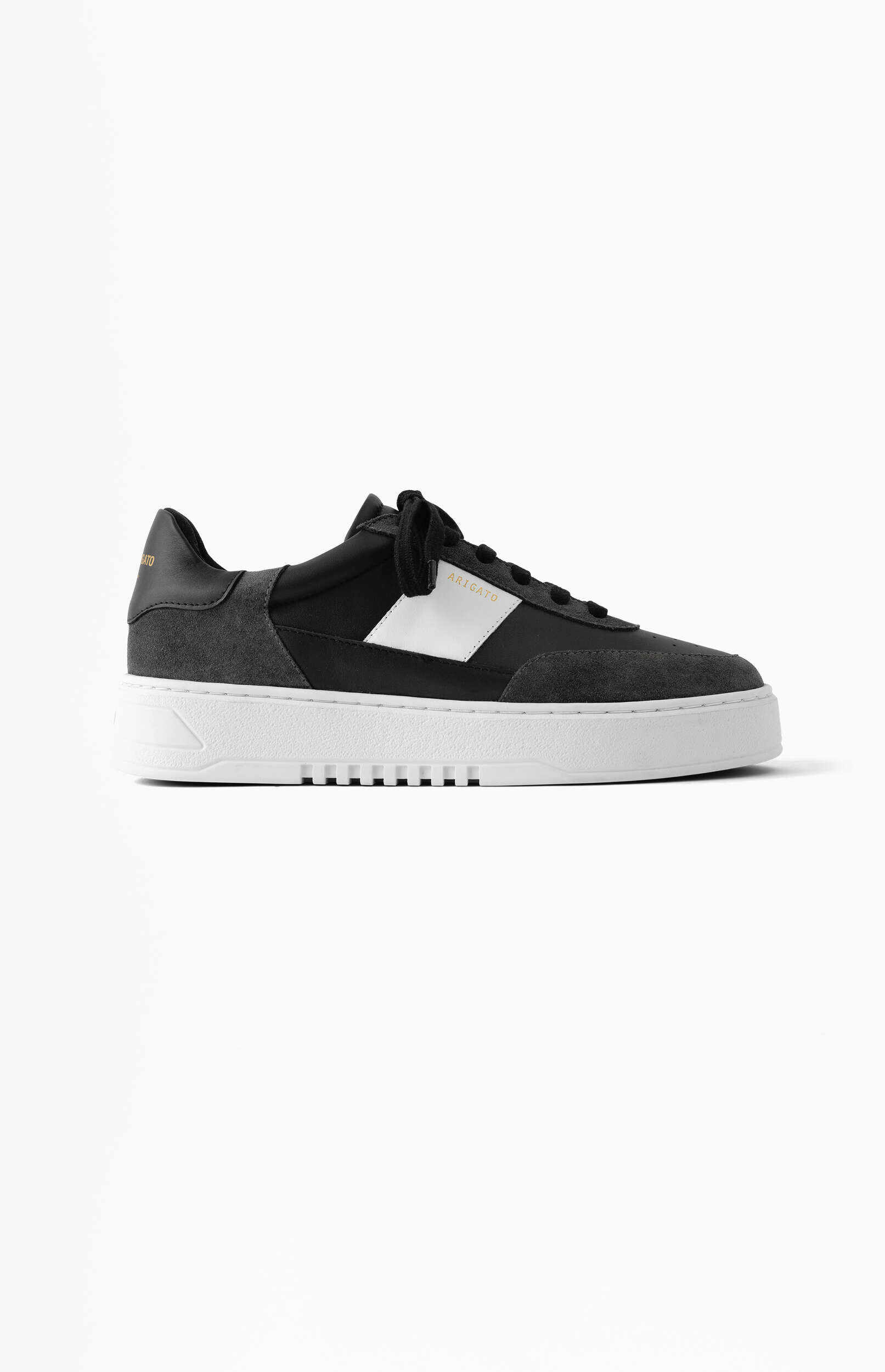 A single black and dark grey athletic shoe with a white stripe accent on the side and a prominent white sole, featuring the brand 'ARIGATO' in gold text. The shoe is positioned on a white background.