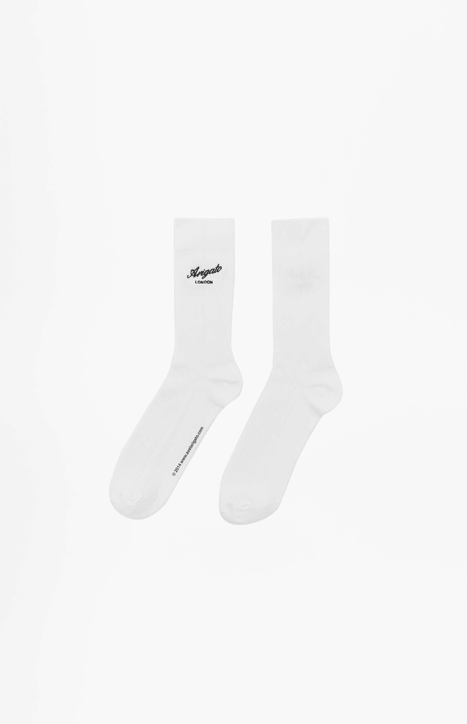 A pair of white crew socks. The left sock features a black 'Arigato London' logo on the upper part and '© 2014 www.axelarigato.com' printed along the sole. The right sock is plain white.