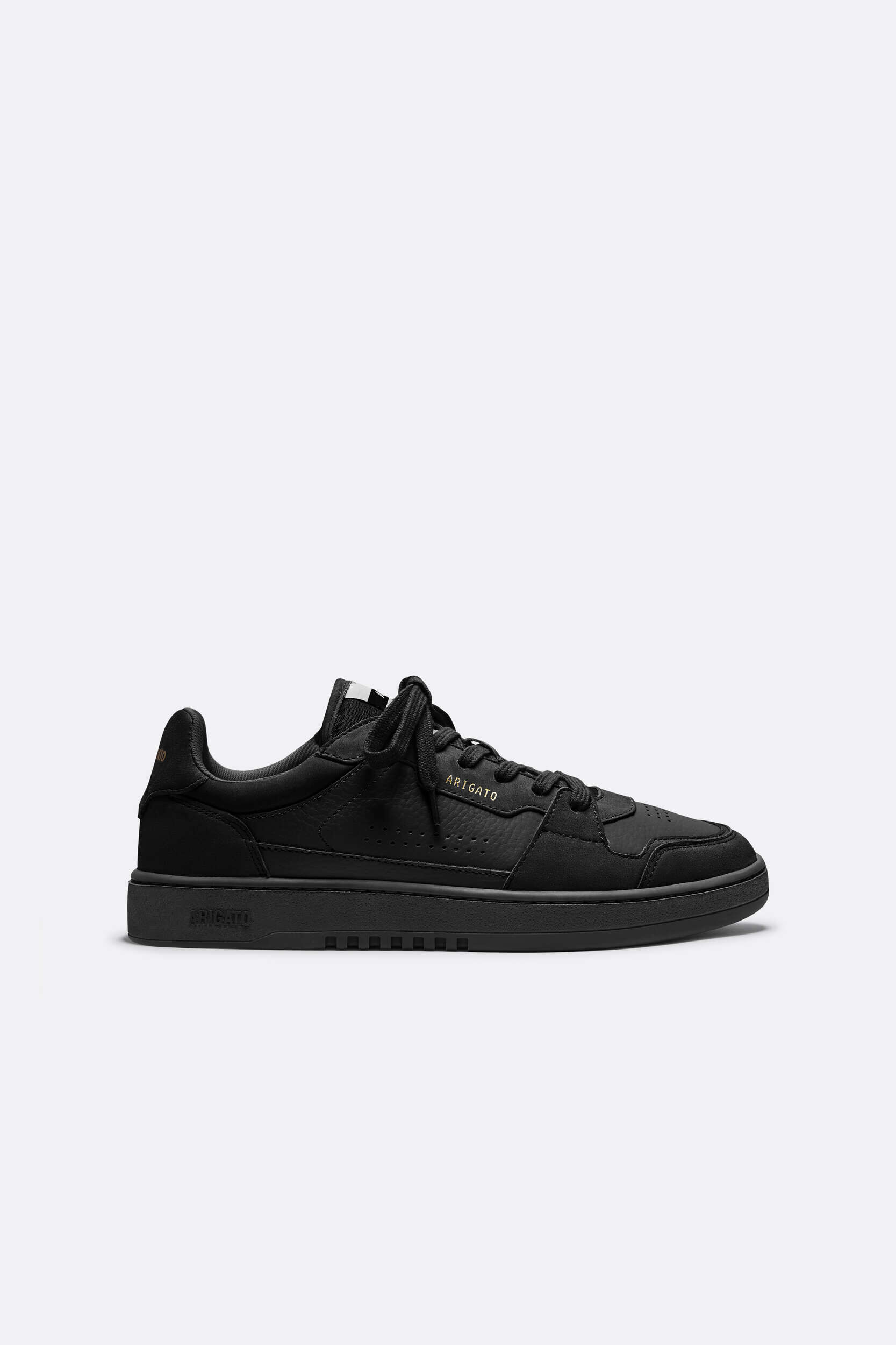 A single black leather sneaker with black laces and a black sole, shown in a side profile view against a plain light background. The brand name 'ARIGATO' is visible in gold lettering on the shoe's tongue.