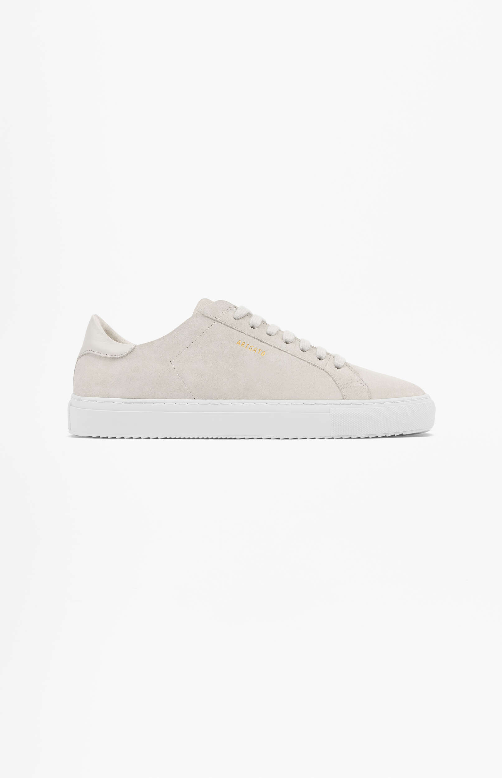 A single light beige suede low-top sneaker with white laces and a thick white rubber sole, featuring the gold 'ARIGATO' brand name on the side, presented on a plain white background.