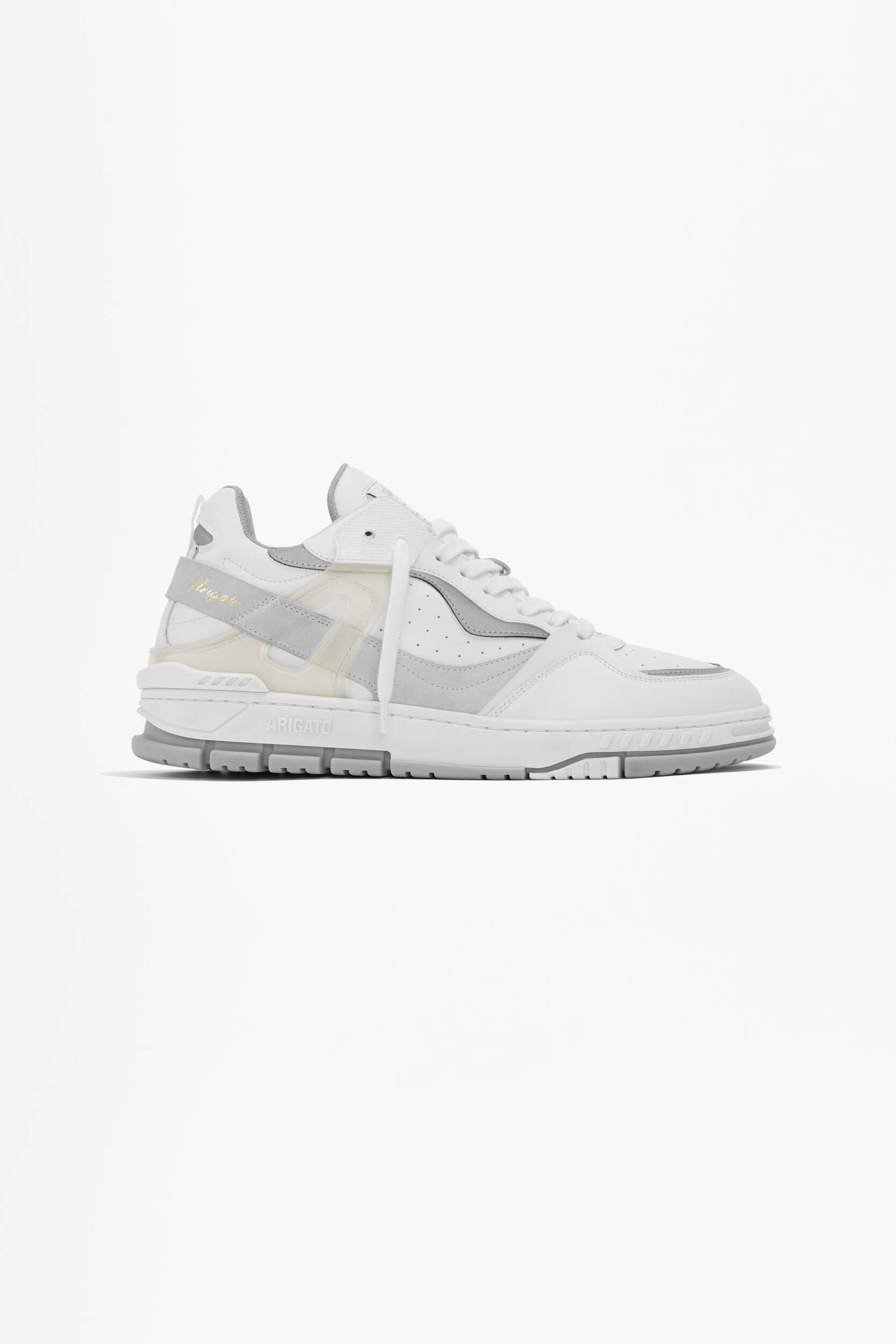 A white and light grey Axel Arigato sneaker with gold lettering on a strap, displayed on a clean white background. The shoe features a blend of materials and a chunky sole.