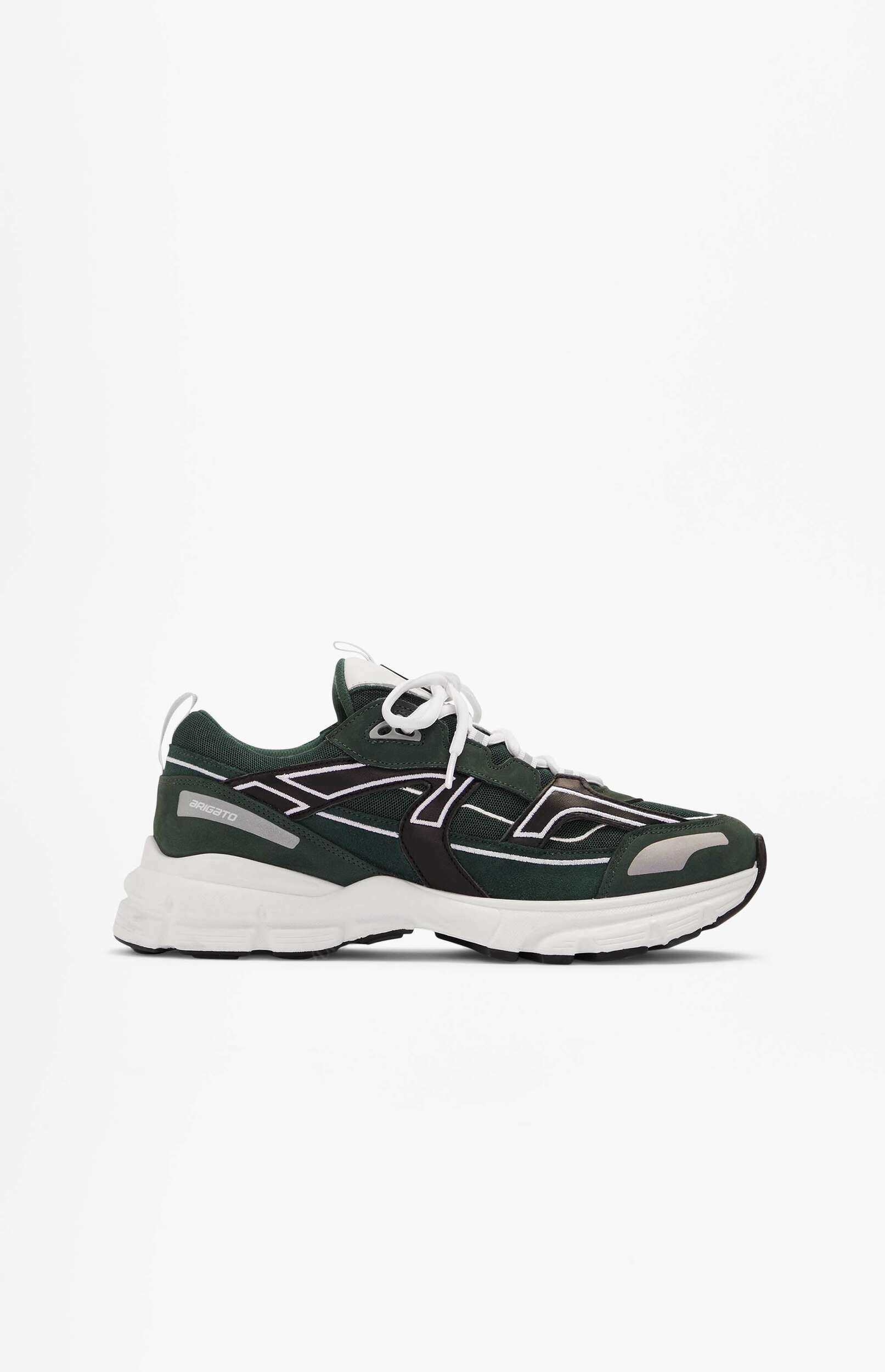 A dark green sneaker with a chunky white sole and white laces is shown in a side view against a plain white background. The shoe features black and white stripe detailing on the sides and 'BRIGATO' branding on a grey patch near the heel.