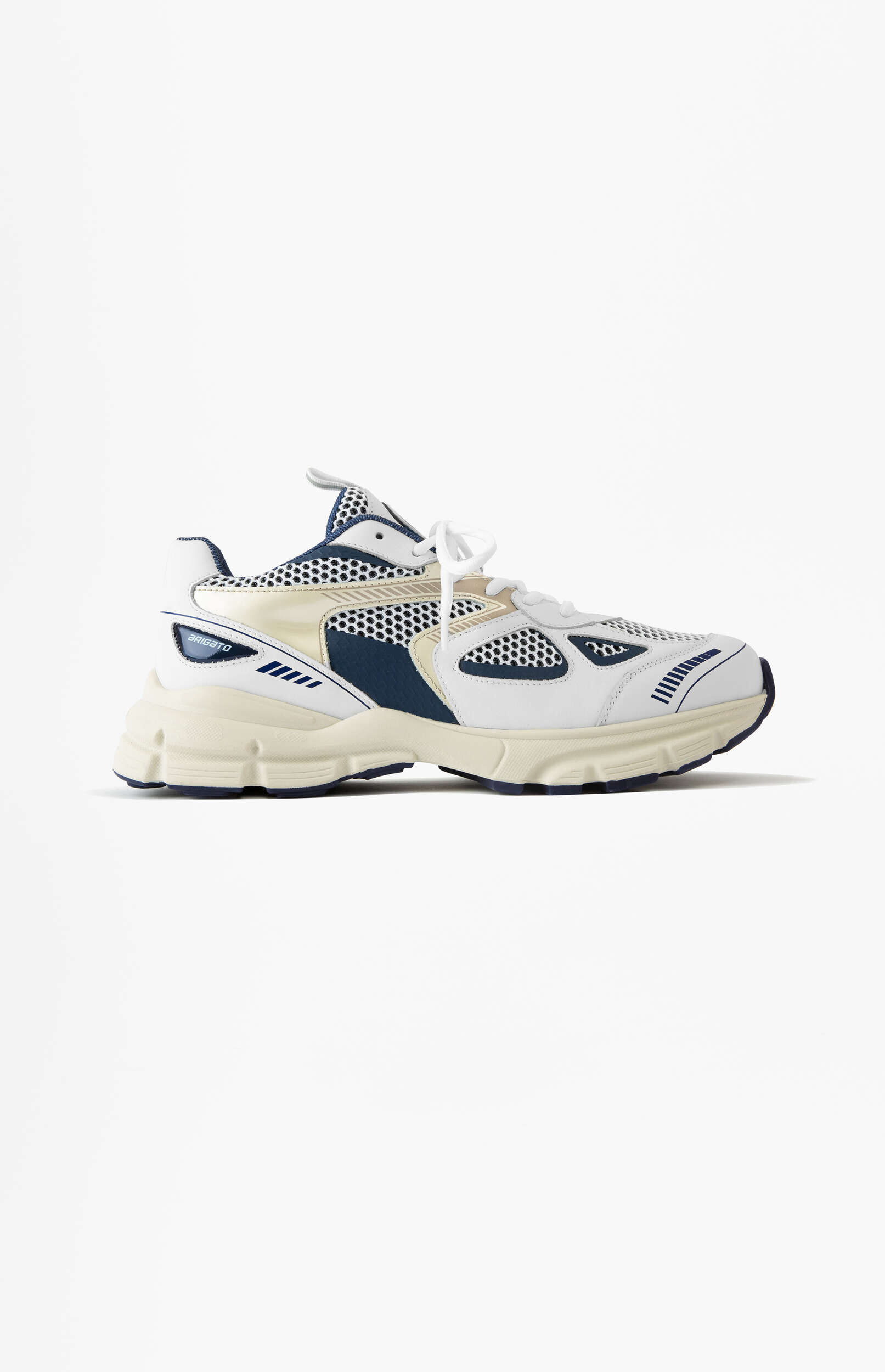 A white and navy blue BRIGATO sneaker with beige accents and a chunky cream sole, featuring mesh and leather-like panels, viewed from the side on a clean white background.