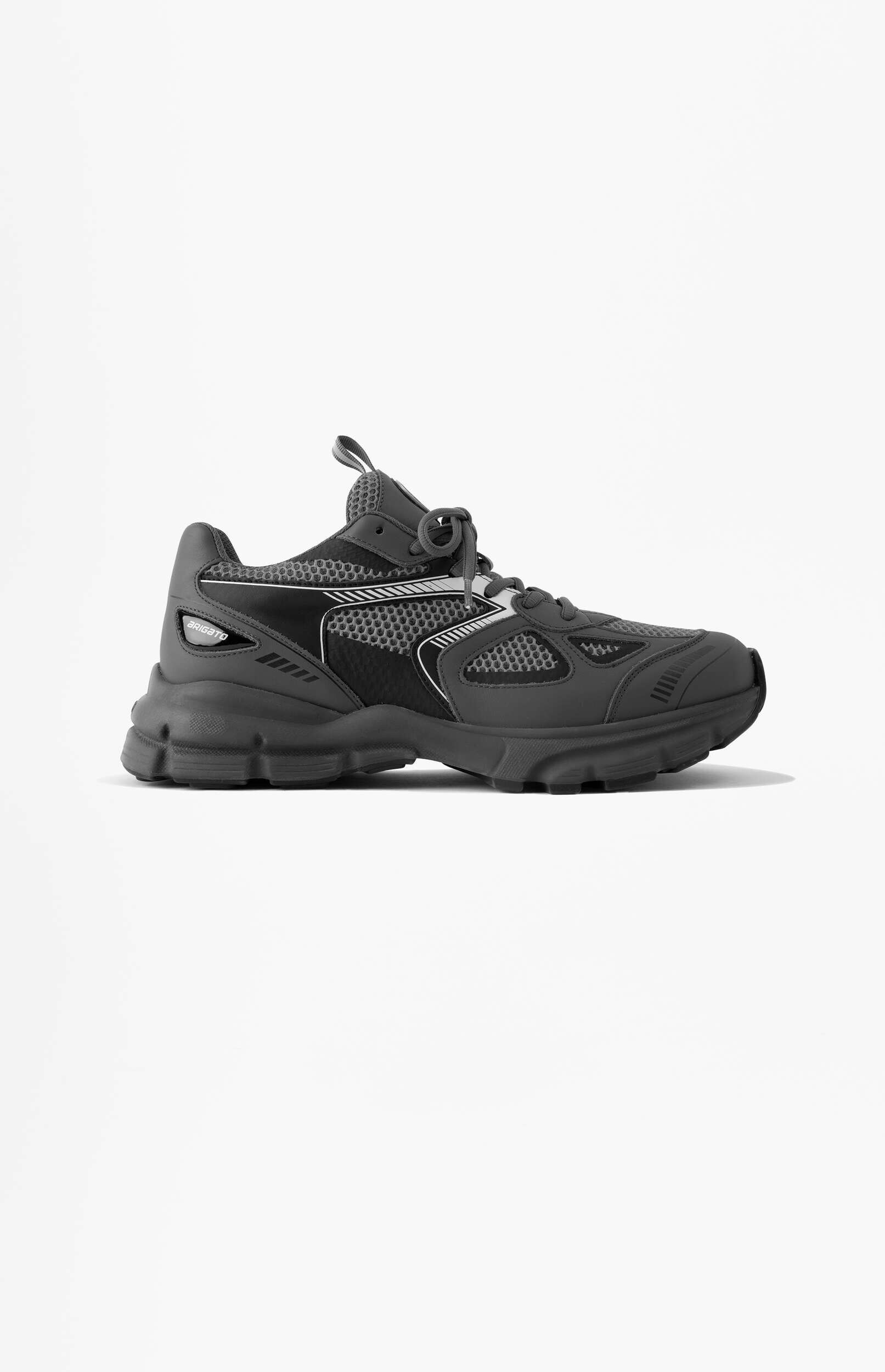 A dark grey athletic sneaker with a mesh upper and chunky sole, featuring the brand name 'BRIGATO' on the side, positioned on a white background.