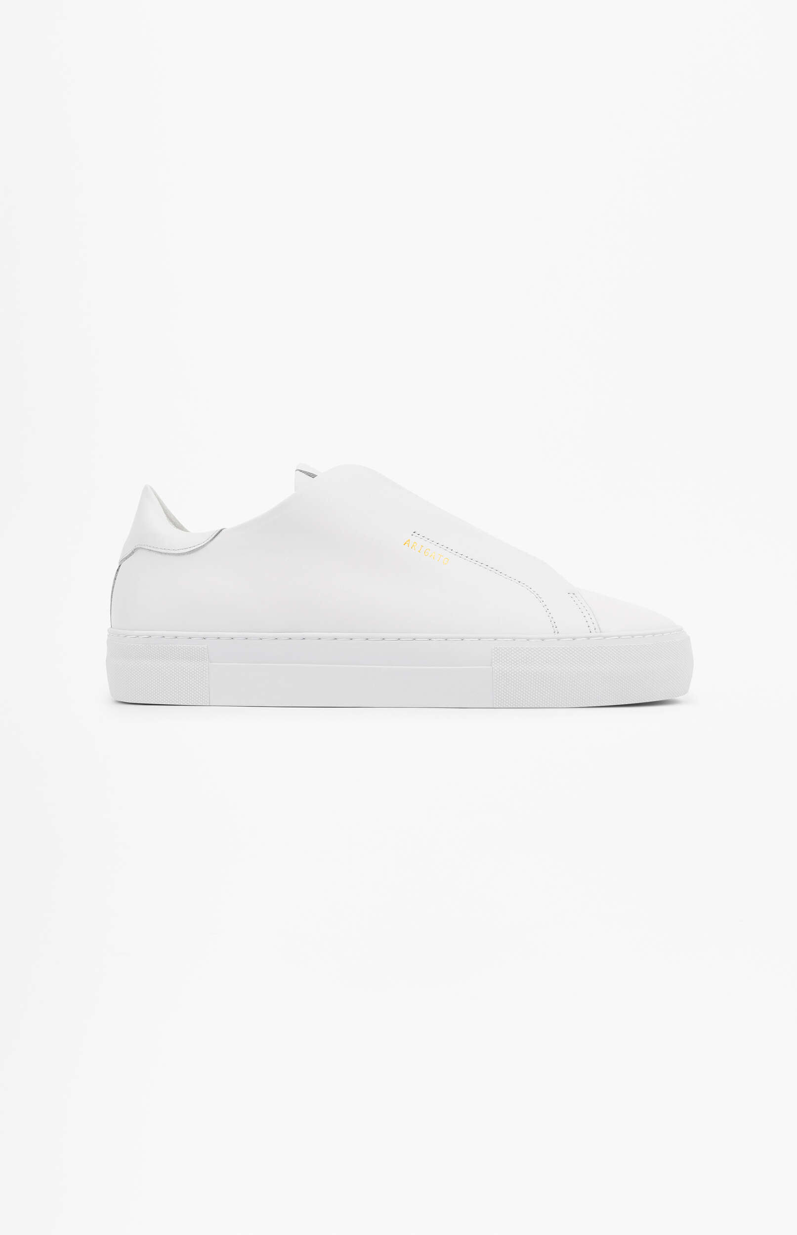 A clean, white slip-on sneaker with a thick sole and subtle gold 'ARIGATO' branding on the side, photographed on a white background.