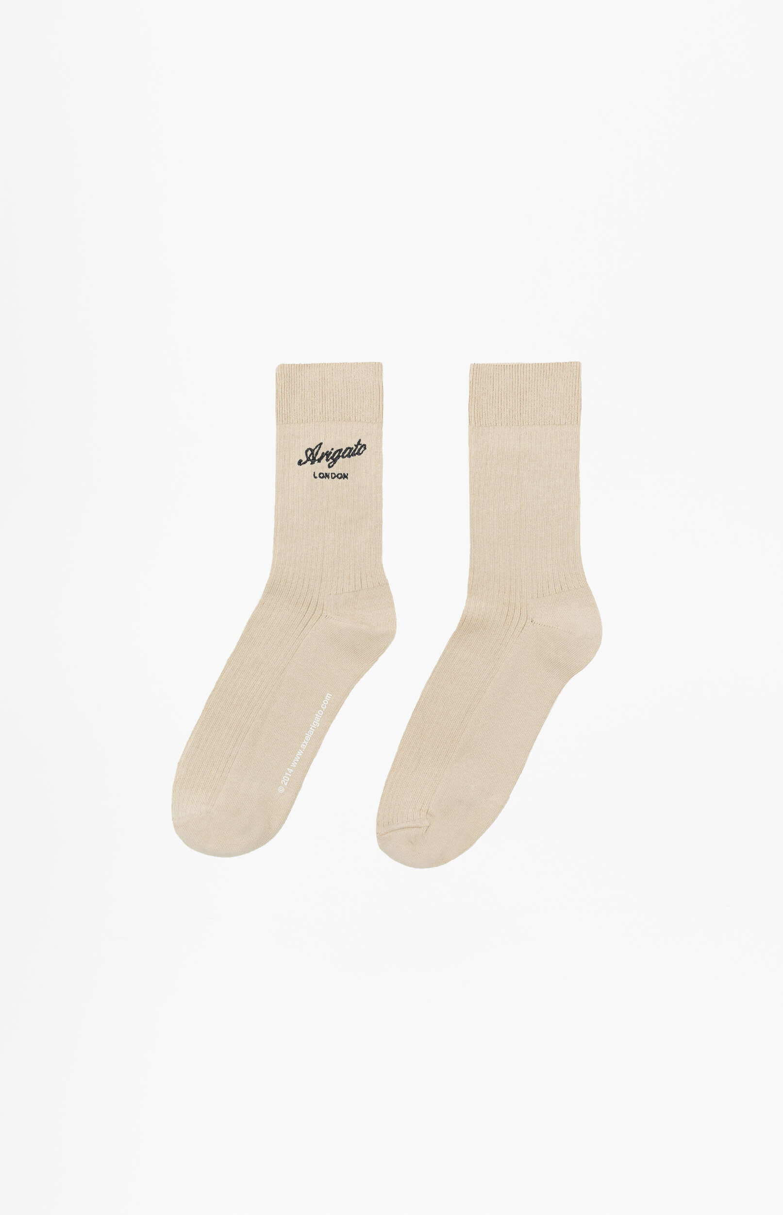 A pair of light beige ribbed crew socks on a white background. The left sock features a black 'Arigato London' logo on the calf and '2014 www.axelarigato.com' printed vertically along the sole.