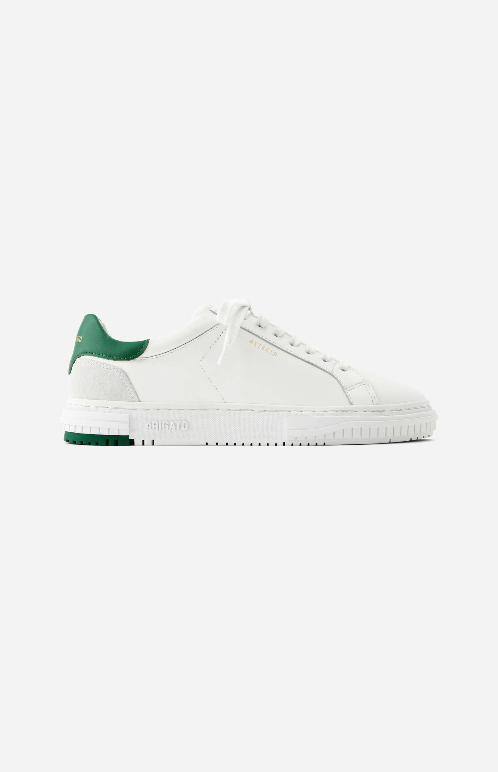 A clean white leather low-top sneaker with a contrasting dark green heel tab and green sole accents, featuring the brand name 'ARIGATO' in gold text on the side, viewed from a side angle on a light background.