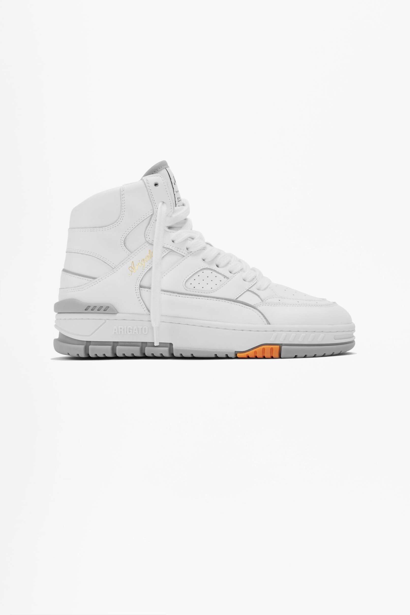 A white high-top sneaker with grey accents on the sole and a small orange detail on the outsole, photographed against a clean white background. The brand name 'ARIGATO' is visible on the side of the sole, and a golden script 'Arigato' is on the upper.