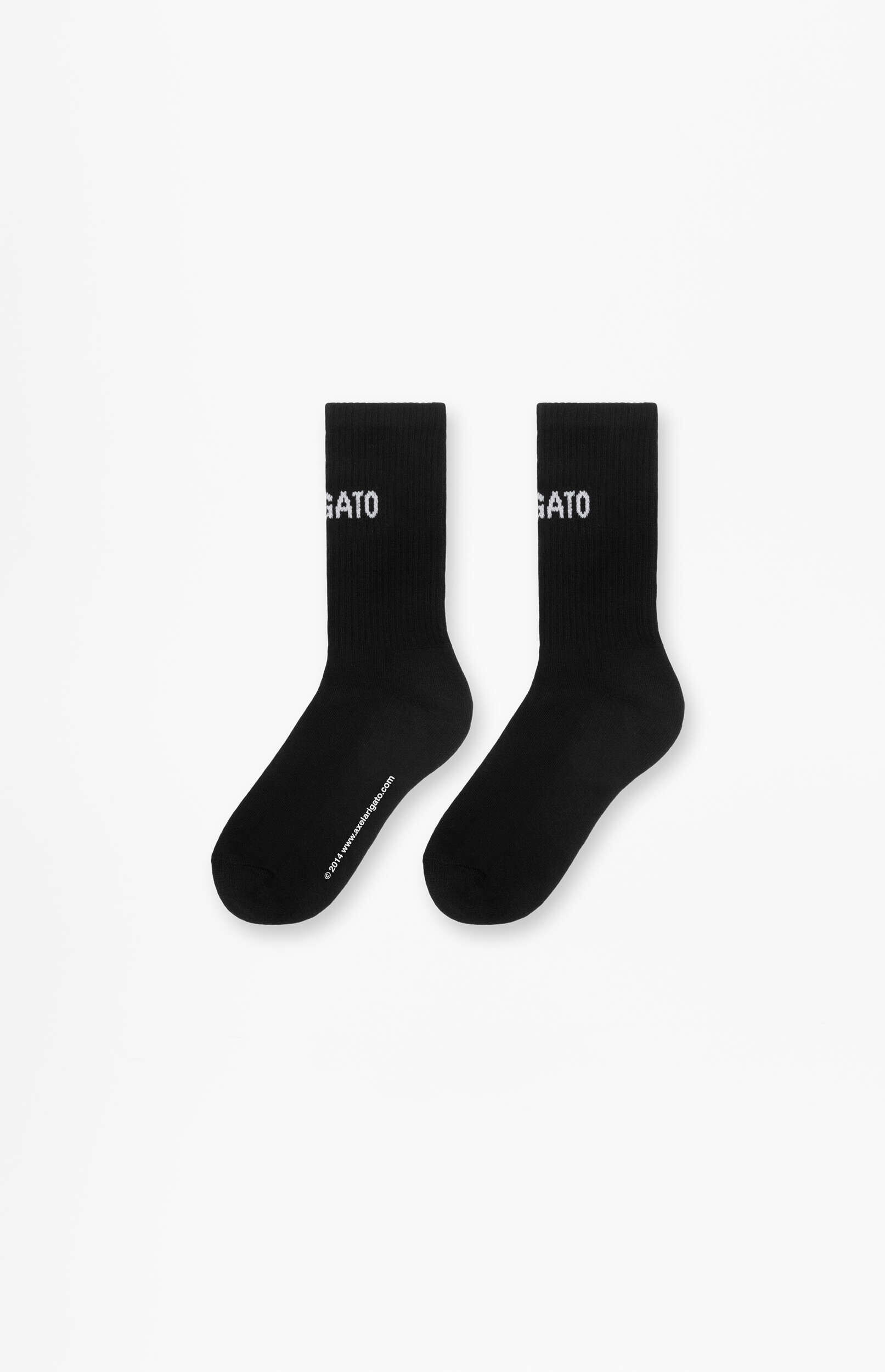 A pair of black crew socks standing upright against a white background. Each sock features the word 'GATO' in white lettering on the ankle, and the left sock has '© 2014 www.axelarigato.com' printed along its lower edge.