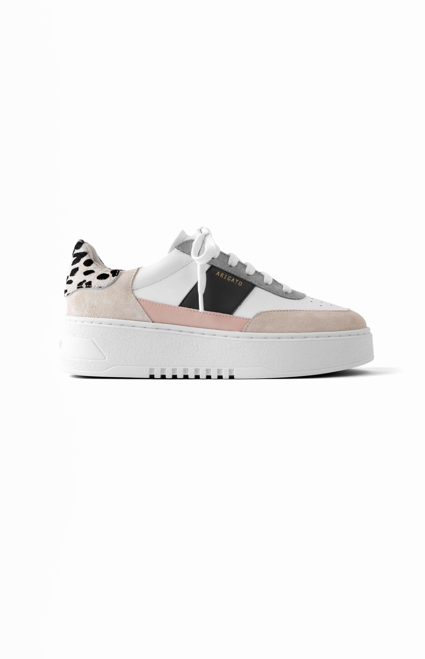 A white platform sneaker featuring light pink, beige, and gray accents, a black stripe with 'ARIGATO' in gold text, and a distinctive black and white dalmatian print on the heel, photographed on a white background.
