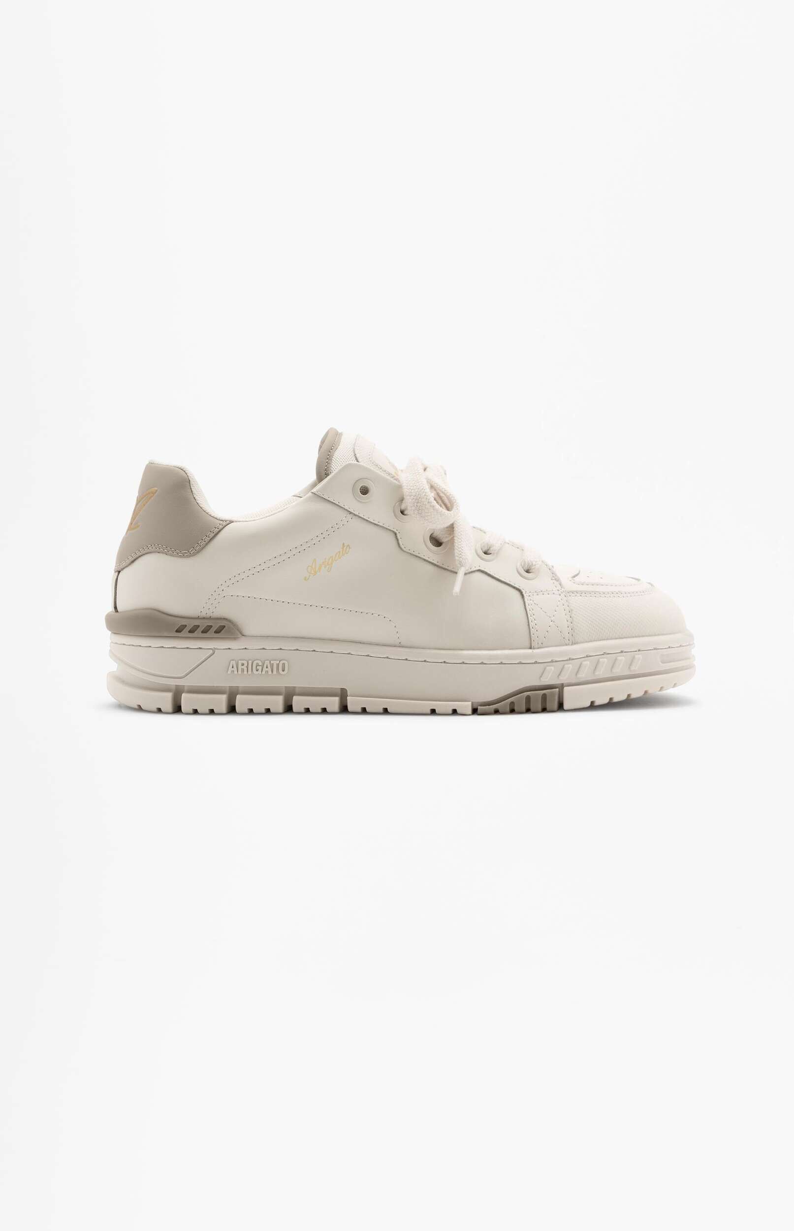 A beige and taupe Axel Arigato Genesis Vintage Runner sneaker displayed on a white background. The shoe is made of leather and mesh, featuring a stacked sole, gold "Arigato" lettering on the side, and a stylized 'A' logo on the heel counter.