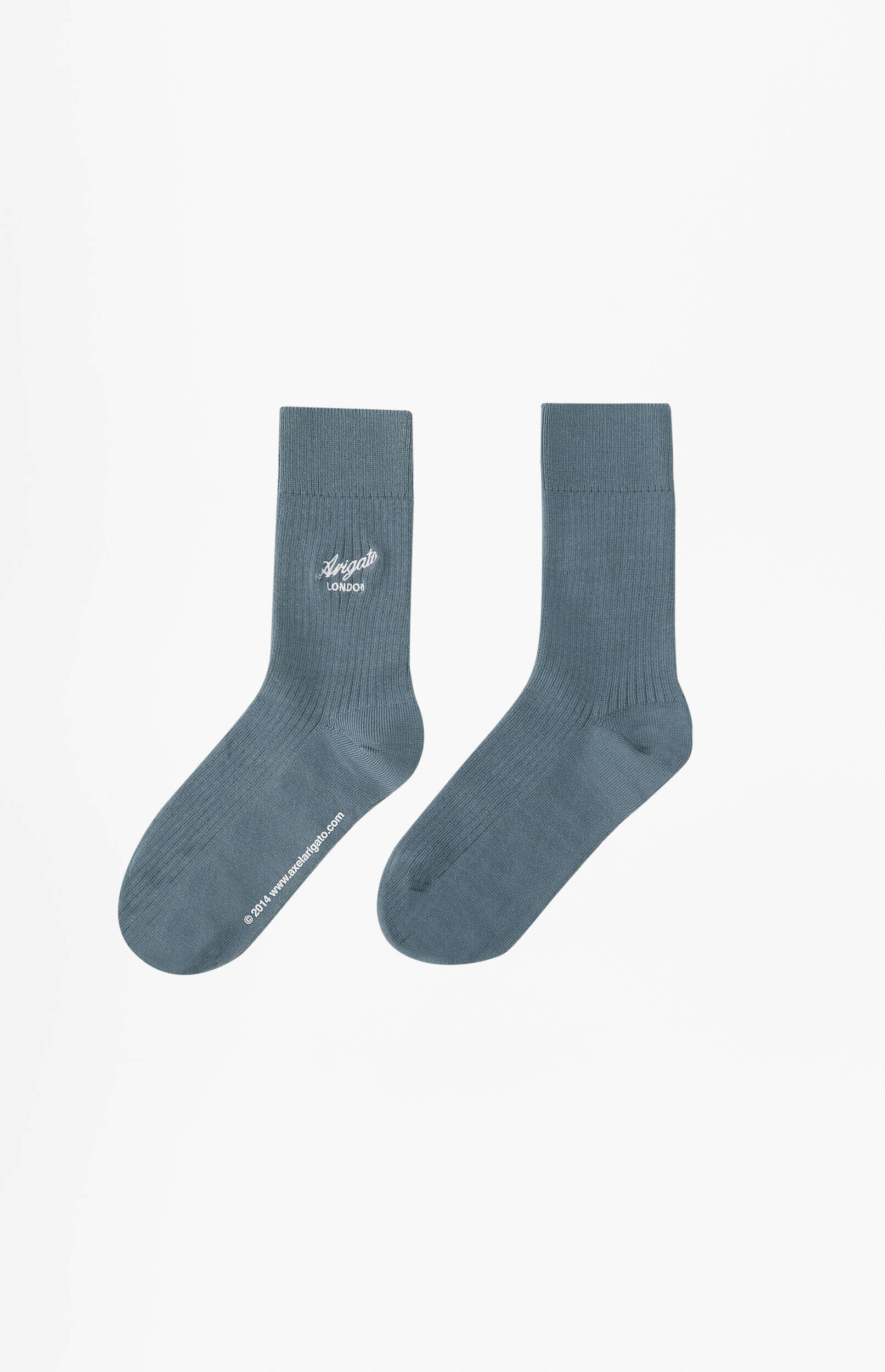 A pair of dusty blue crew socks, with the left sock featuring white 'Arigato London' branding and a copyright notice '© 2014 www.axelarigato.com', presented upright on a clean white background.
