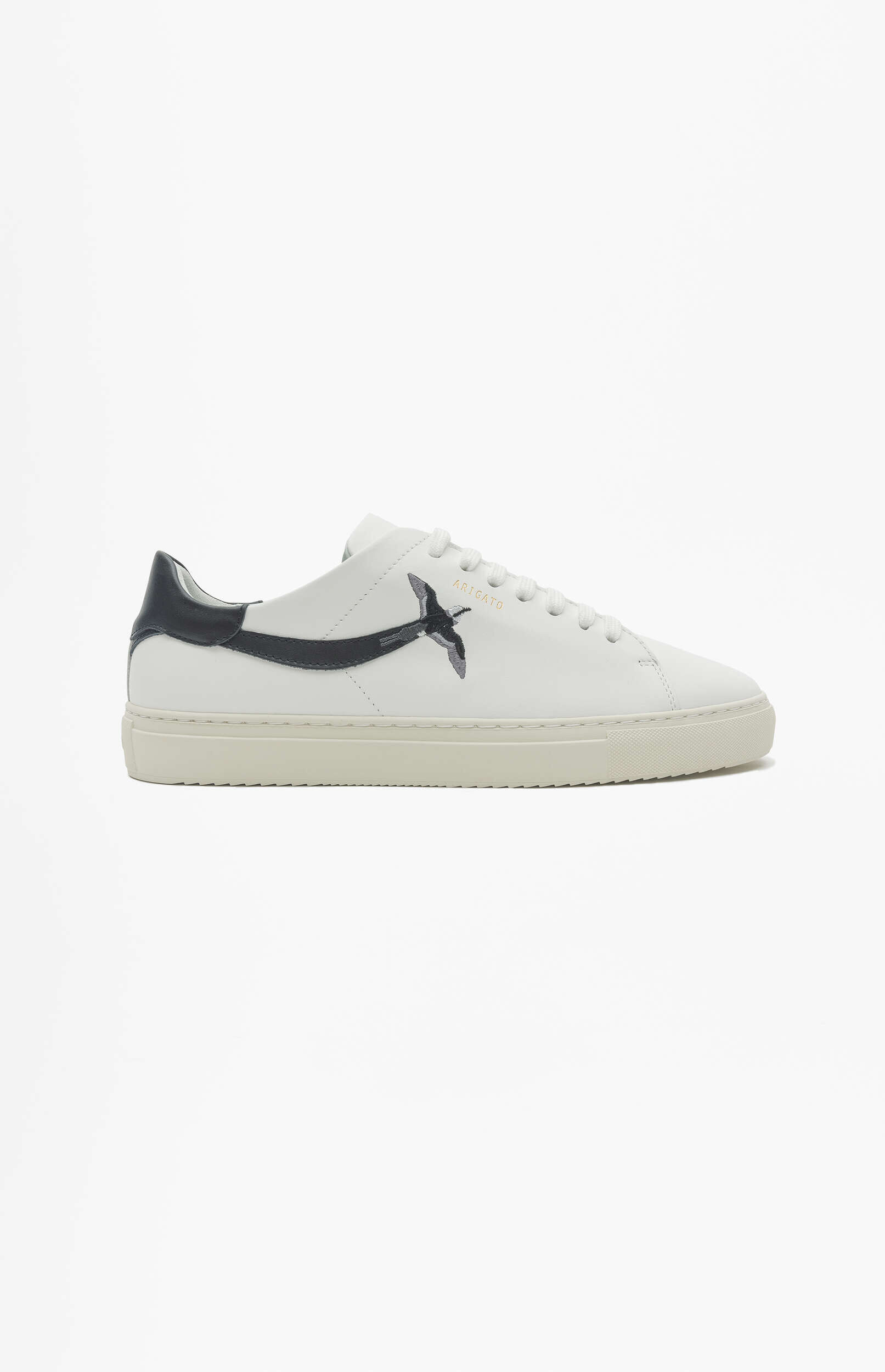 A white Axel Arigato Clean 90 sneaker with a black swallow bird embroidered on the side, a black heel tab, and white laces, shown on a clean white background.