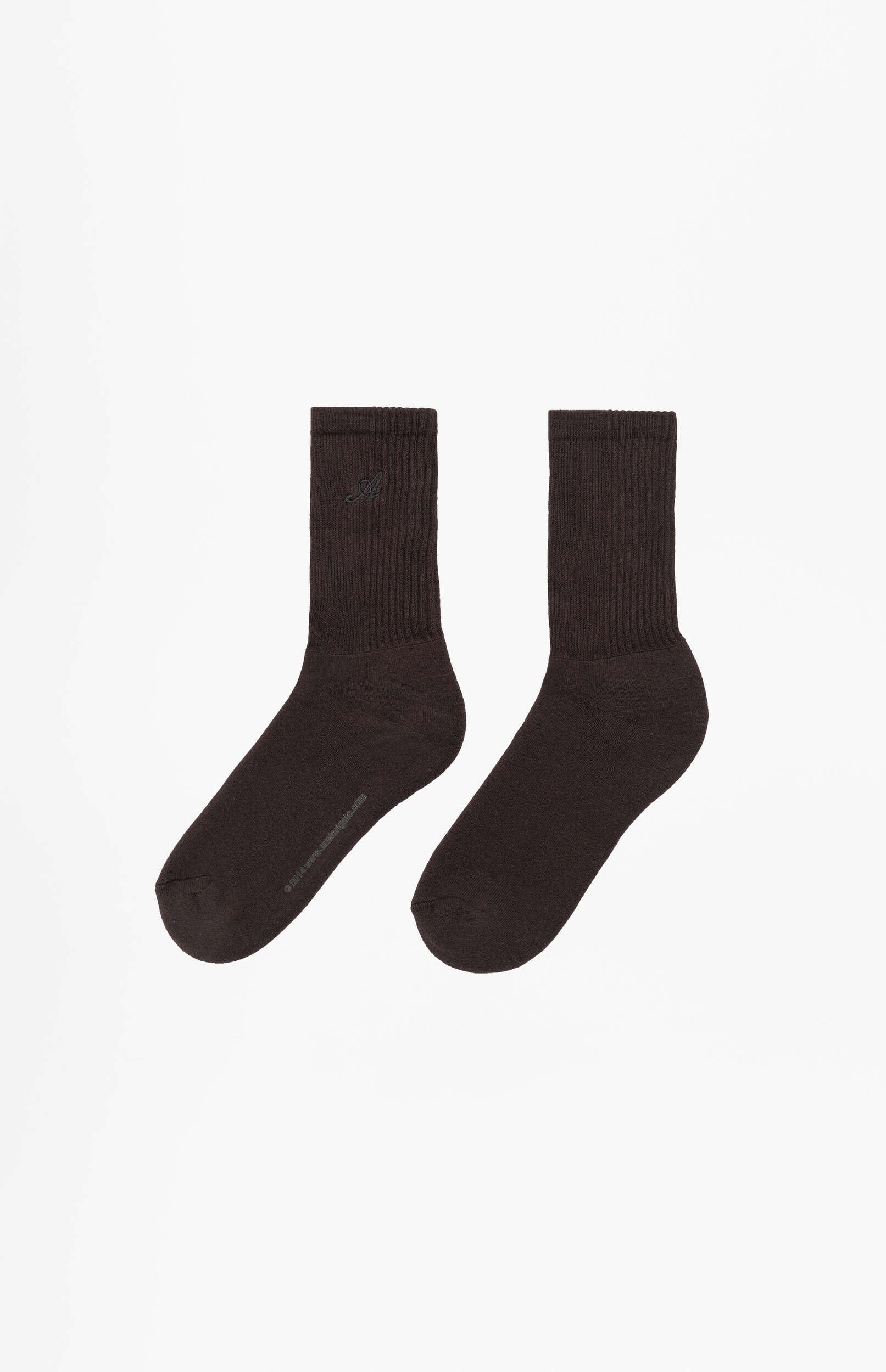 A pair of dark brown, ribbed crew socks displayed on a white background. One sock has a subtle embroidered logo, appearing to be a stylized 'A', near the cuff.