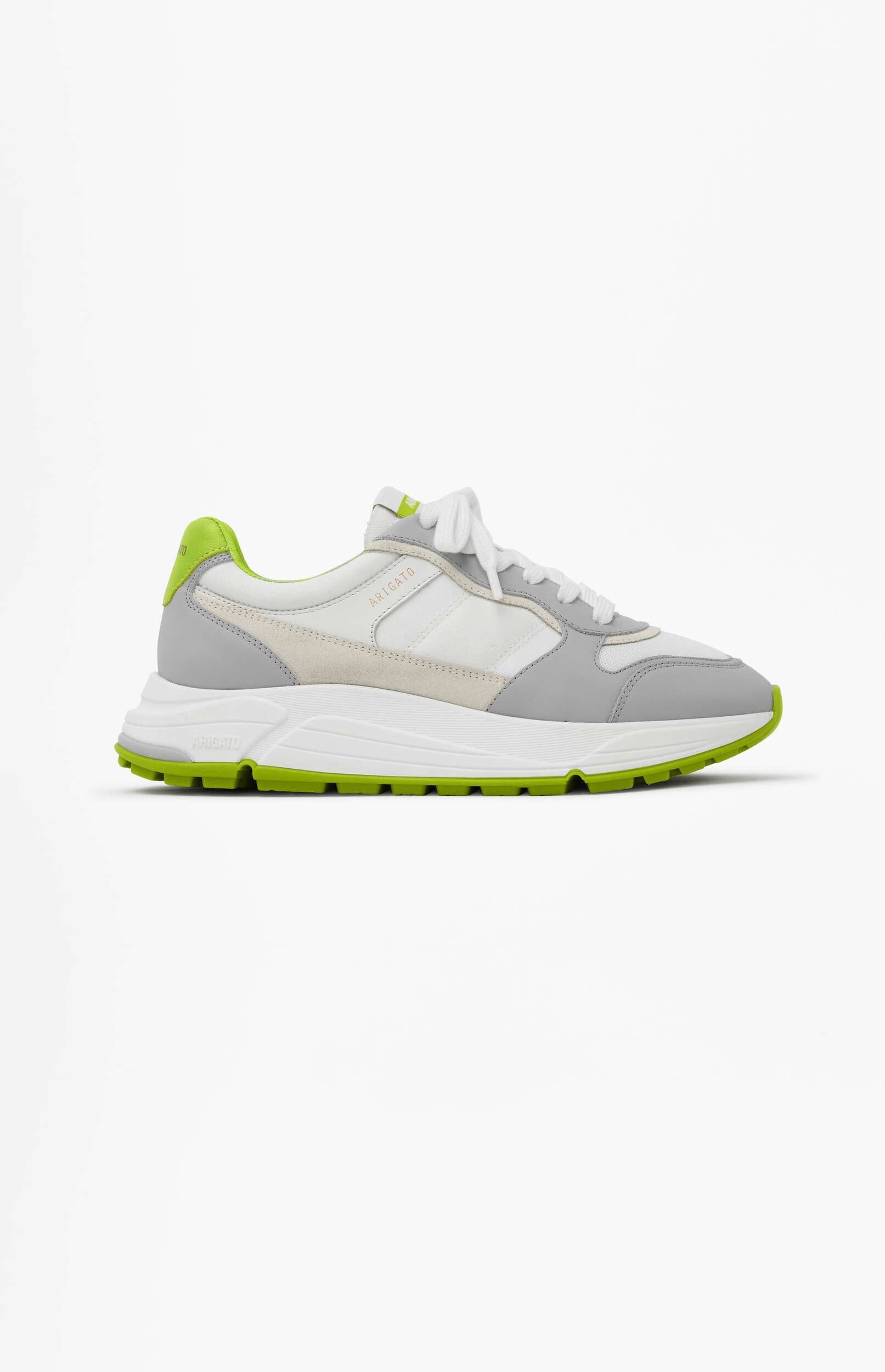 A white and light grey Axel Arigato Genesis sneaker with vibrant neon green accents on the heel and outsole, displayed from a side view against a plain white background.