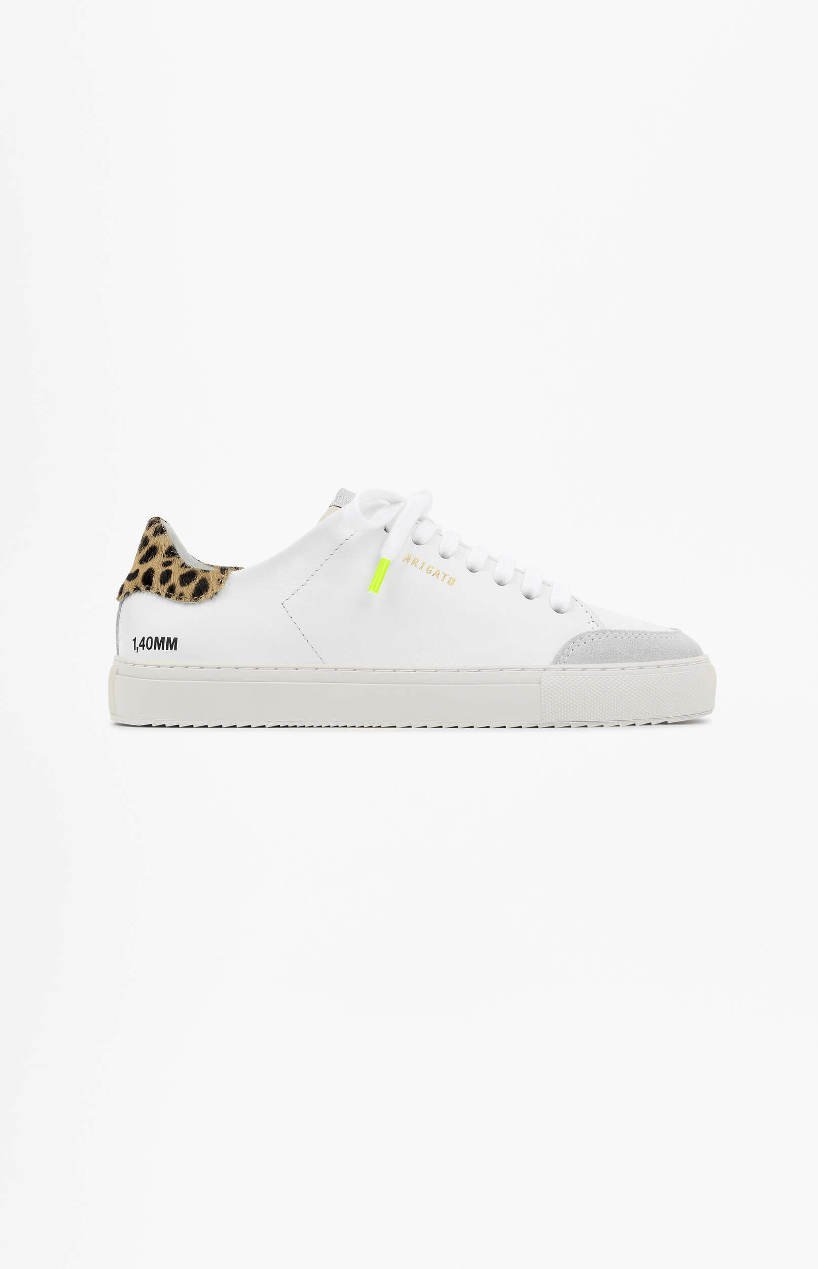A white sneaker with a leopard print heel tab, grey suede toe cap, white laces with a neon yellow lace stopper, and the brand name 'ARIGATO' in gold text on the side, displayed on a plain white background.